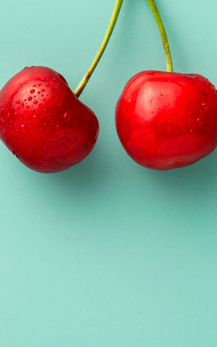 two plums connected by a stalk